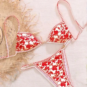 Rödvit blommig bikinitopp - Snygg bikini underdel i röd och vit med blommigt mönster. Triangelformad överdel med smala axelband och dekorativa sömmar längs kanterna. Aldrig använd
