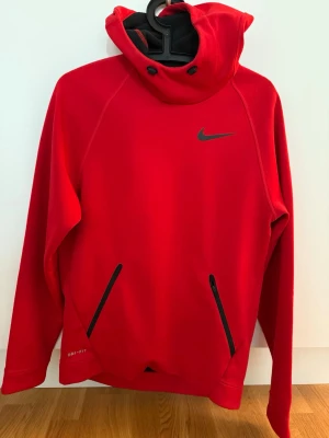 Nike hoodie - Röd Nike hoodie i dri-fit material, dvs perfekt för träning både inomhus och utomhus. I mycket fint skick. Hör av er vid frågor/ funderingar, mvh .