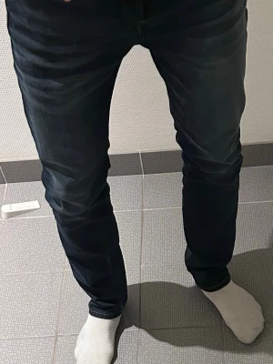 Jack & Jones mörkblå jeans straight fit - Säljer ett par  jeans i mörkblå tvätt med straight fit. Femficksmodell med kontrastsömmar. Perfekta för dig som gillar stilrena jeans personligt. 
