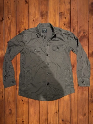 Vintage Abercrombie&Fitch overshirt (sällsynt) - Säljer denna vintage sällsyna och asfeta overshirten från Abercrombie&Fitch. Riktigt fet och den är i väldigt bra skick och är riktigt snygg med en hoodie under. Storlek är S och den passar som S se måtten nedan B=70cm A=52cm