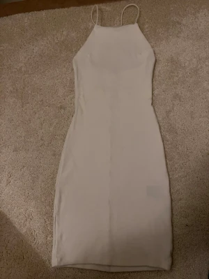 Vit ribbad kortklänning med tunna band - Säljer en enkel och stilren vit ribbad klänning med tunna axelband. Aldrig använt😊