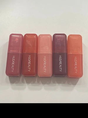 Huda Beauty Blush Filter kit  (värde 1800kr) - Säljer fem populära Huda Beauty Blush Filter liquid blush i färgerna Strawberry Cream, Watermelon Pop, Cotton Candy, Black Cherry och Peach Sorbet.  Nyansskalan går från ljusrosa till mörkbärig och persikotonad.  🩷🧡💜❤️                                                       Flytande rouge med krämig formula, hög pigmentering och byggbar finish som ger ett fräscht, naturligt glow. Lätt att blenda och sitter länge på huden. ✨.     Använts 1-3 ggr (peach sorbet oanvänd) nypris st: 359kr 