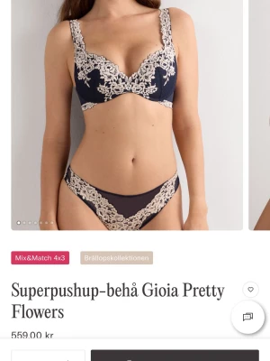 Bh från intimissmi Gioia Pretty Flowers - Snygg bh i mörkblått med ljusa spetsdetaljer och blommigt broderi. Bh:n har pushup-modell och tunna axelband med spets längs kanterna. Perfekt för dig som vill ha något extra fint under kläderna.