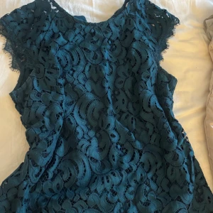 Mörkgrön spetsblus med kort ärm - Säljer en mörkgrön/blå blus i  spets med korta ärmar