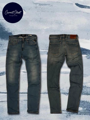 Replay Anbass blå jeans herr 31/34 - Säljer ett par Replay Anbass jeans i klassisk blå tvätt med snygga slitningar och kontrastsömmar. Jeansen ser brunare ut pga konstigt ljus.