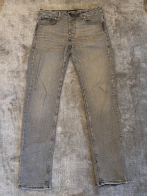Grå slim/straight jeans från Jack & Jones - Säljer ett par ljusgrå jeans från Jack & Jones, modell Tapered/Mike. Jeansen har klassisk femficksdesign, normal midja och avsmalnande ben. Materialet är mjukt jeans-tyg i bomullsmix och färgen är snyggt tvättad grå. Perfekta till sneakers och hoodie, eller skjorta vid finare tillfällen👌