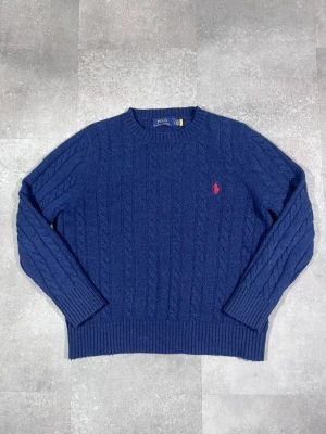 Ralph Lauren cable knit - Säljer en Ralph Lauren cable knit sweater i snygg mörkblå färg. 🧵 Märke: Ralph Lauren 👕 Storlek: Medium (men passar mer som S) 🎨 Färg: Mörkblå / navy 📌 Design: Klassisk cable knit-stickad tröja 📍 Skick: Mycket bra, se bilder!  Beskrivning: • Tidlös och stilren cable knit-design från Ralph Lauren • Bekväm och varm – perfekt för höst och vinter • Ribbstickade muddar och kant för bra passform • Inga fläckar, noppor eller skador (kontrollera bilder) • Lätt att matcha med jeans, chinos eller över skj