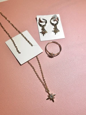 Smyckesset  - Ett guldigt smyckesset från guldfynds julkalender 2024 som består av ett halsband, en ring och örhängen. Allt är oanvänt förutom ringen som har använts vid 2-3 tillfällen💛