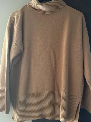 Beige polotröja från Chiquelle - Säljer en beige polotröja från Chiquelle i storlek XS/S. Tröjan har ribbade detaljer vid krage, ärmslut och nederkant samt en relaxed passform. Perfekt för lager på lager under höst och vinter. Supermjuk och enkel att styla till allt.