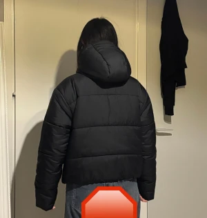 Svart pufferjacka från Nike - Säljer en svart pufferjacka från Nike med huva och dragkedja framtill. Jackan har en boxig passform, långa ärmar och diskret Nike-logga på bröstet. Perfekt för kalla dagar och riktigt snygg till jeans eller cargo. Materialet är syntet och jackan är quiltad för extra värme.