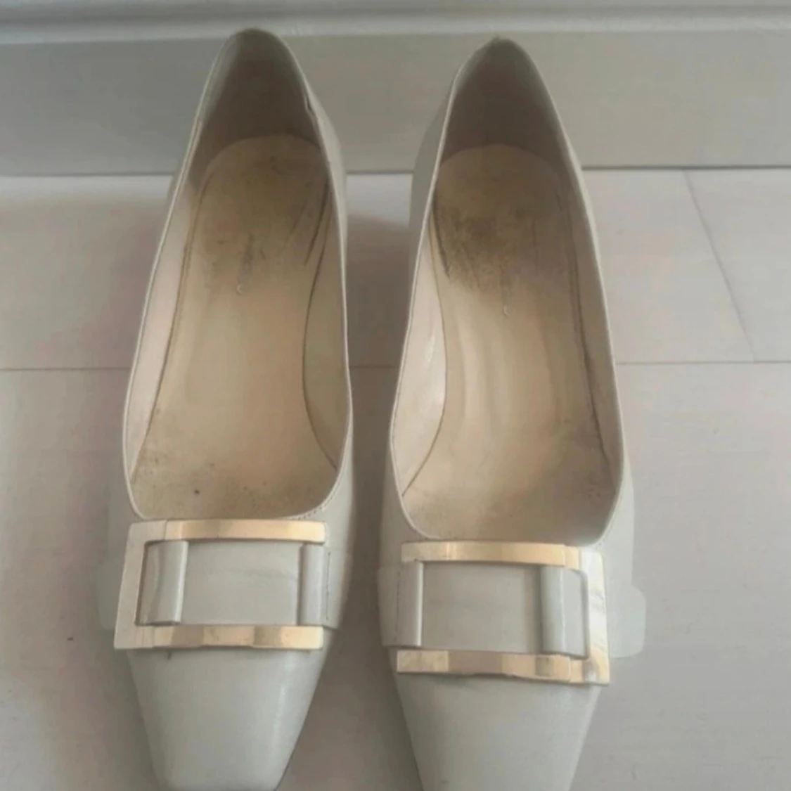 Vita klackskor med gulddetalj