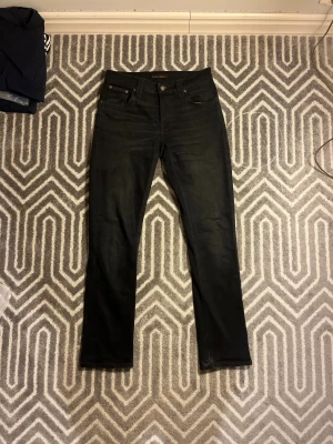 Nudie Jeans Grim Tim Svarta - Säljer ett par riktigt feta svarta jeans från Nudie Jeans, av modellen Grim Tim. Snygga med riktigt fin passform. Inga defekter, egentligen så gott som nya! Tveka inte på att höra av dig ifall du undrar nåt!✨