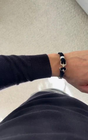 Marinblå armband med ankardetalj - Snyggt marinblått armband med dubbla rep och en cool silverfärgad ankare som lås. Detaljer i vitt ger extra kontrast och en nautisk vibe. Perfekt accessoar för dig som gillar stilrena och unika smycken.