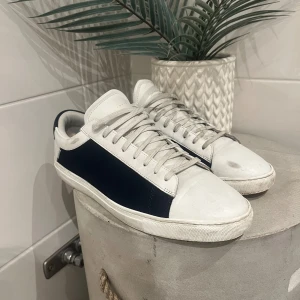 Oliver Cabell The Low 1 Yin Yang Sea Salt Sneakers - Oliver Cabell The Low 1 “Yin Yang Sea Salt” sneakers i storlek 44. Handgjorda i premiumläder med stilren design i vitt och svart. Använda men i fint skick – en ordentlig rengöring så ser de nästan nya ut.