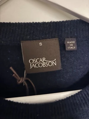 Stackad tröja Oscar Jacobsson - En helt NY och därmed oanvänd stickad tröja från Oscar Jacobsson med tag kvar. Tillverkad i ull, och är i storlek S. En tröja som sitter snyggt och passar till alla typer av sammanhang. Tröjan passar personen som vanligtvis bär storlek S-M.   Kolla gärna in andra tröjor jag säljer!