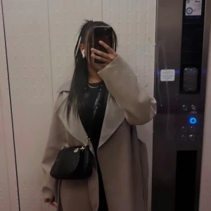 Beige kappa med stora slag - Säljer en snygg beige kappa med stora, svepande slag och lång passform. Jackan har en stilren look och är perfekt för dig som gillar minimalistisk stil. Långärmad och i mjukt material som känns skönt mot huden. Passar perfekt till höst och vår.