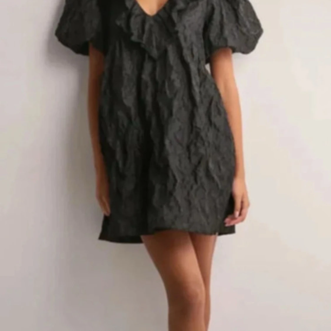Svart kort klänning med volang