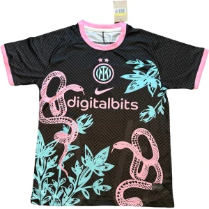 Inter Milan x Nike svart fotbollströja - Unik Inter Milan fotbollströja från Nike i svart med rosa detaljer och tryck. Tröjan har korta ärmar, rosa ormar och turkosa växter på framsidan, samt klubbmärke och Nike-logga i rosa. Tillverkad i lätt och ventilerande polyester för maximal komfort.