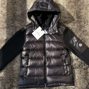 Moncler Maglione Tricot Cardigan - Otroligt snygg🙌 och stilren cardigan från Moncler i svart färg, storlek L/3 men passar M. Jackan är i riktigt fint skick och passar perfekt både till vardags😁 och kyligare kvällar❄️. Modellen heter Maglione Tricot Cardigan❗️, en av Monclers mest populära hybridplagg som kombinerar lätt dunväst framtill med stickade ärmar i premium bomull/ull🐑Denna cardigan köptes i butik i Milano under en weekendresa förra året, Men är gott som ny för den inte har använts,🛍️ Kontakta mig✅