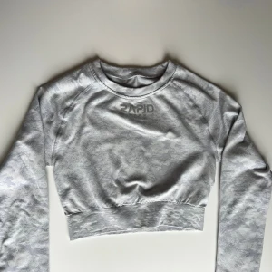 Rapid wear Träningstopp - Säljer en ljusgrå träningstopp från Rapid wear i storlek S!