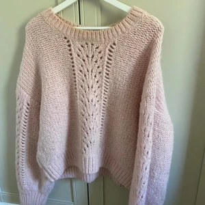 Ljusrosa stickad tröja & Other Stories - Supermysig ljusrosa stickad tröja från & Other Stories med snyggt hålmönster framtill. Modellen är loose fit med långa ärmar och bred ribbad kant vid hals, ärmslut och nederkant. Perfekt för att hålla sig varm och ändå se cute ut! Perfekt nu till hösten. Lite missfärgad upptill men det syns inte, storlek L men passar som en S/M