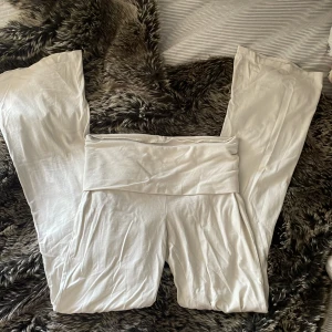 Vita mjuka lågmidjade yogapants - Superbekväma vita lågmidjade yogapants med bred linning. Byxorna är raka i modellen och gjorda i ett mjukt, stretchigt material som känns skönt mot huden. Perfekta för chill eller yoga. Snygg minimalistisk look.