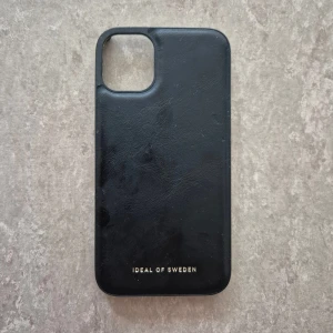 Mobilskal - Fin svart skal från iDeal of Sweden för iPhone 11. Passar perfekt för dig som vill ha ett stilrent och prisvärt skydd.
