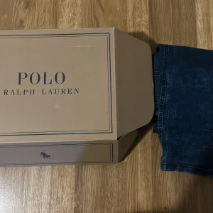Blå jeans från Polo Ralph Lauren - Snygga blå jeans från Polo Ralph Lauren. Klassisk rak passform med fem fickor och diskreta sömmar. Jeansen har en djupblå färg och är tillverkade i ett slitstarkt bomullsmaterial. Perfekta för dig som gillar stilrena och tidlösa jeans.