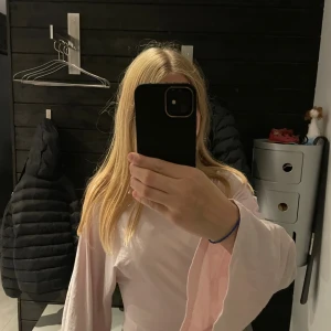 Ljusrosa långärmad topp med vida ärmar - Säljer en ljusrosa långärmad topp från Lager 157. Toppen har vida, nästan trumpetformade ärmar. Enkel och clean design med rund halsringning, perfekt för dig som gillar en chill och trendig look.