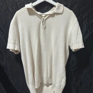 Zip-up piké, Zara - Säljer en riktigt snygg zip-up pikétröja från Zara. Tröjan är beige/vit med schysst mönstrerat tyg. Jag säljer den för att den tyvärr inte kommer till så stor användning. Det är lite missfärgning som man ser på sista bilden runt kragen. Men den är fortfarande i strålande skick. Storlek M skick 7/10.