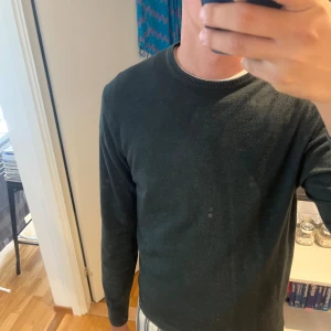 Mörkgrön stickad tröja Daniele Fiesoli - Mörkgrön stickad tröja från Daniele Fiesoli med rund halsringning och ribbade muddar. Enkel och stilren design, perfekt för lager-på-lager. Tillverkad i Italien och har lång ärm. Passar dig som gillar klassiska och snygga plagg. nypris 1699kr