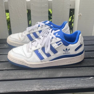 Adidas forum low blå skor - Mycket bra skick och fortfarande bra färg, inte så smutsiga. Mindre skavanker (3 sista bilder) tyget i ena hälen, crease och små sprickor på sista bilden. Nypris 800-1000 köpta 2 år sen men inte använts på länge.