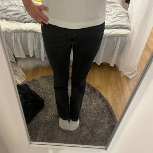 Svarta jeans - Säljer ett par svarta jeans med rak passform och klassisk femficksdesign. Jeansen har normal midja och är tillverkade i ett mjukt denimtyg som sitter snyggt på benen. Perfekta för dig som gillar en stilren och enkel look.