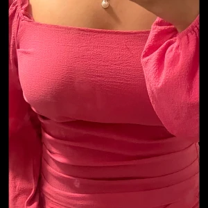 Rosa tvådelat set - Rosa tvådelat set från SHEIN, köpt separat. Setet består av en långärmad topp och en kjol, båda i samma rosa färg. Toppen har en knutdetalj i midjan. Jätte söt! Älskar den! Blusen är storlek:M/L och kjolen är storlek:L