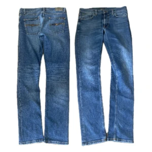 Nudie jeans blå jeans straight fit - Klassiska blå nudie jeans jeans med rak passform och femficksdesign. Jeansen har normal midja, knappgylf och slitna detaljer på bakfickorna. Tillverkade i robust denim som ger en tidlös look.                                                                   W33/L34