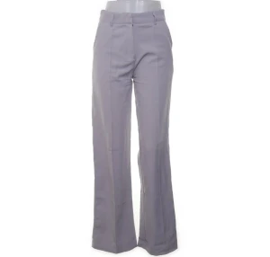 Grå kostymbyxor med bootcut - Snygga ljusgrå kostymbyxor med bootcut och från madlady. Byxorna har pressveck framtill, bälteshällor och klassisk stängning. Perfekta för en clean och stilren look. Materialet känns mjukt och följsamt. Storlek xs/s.