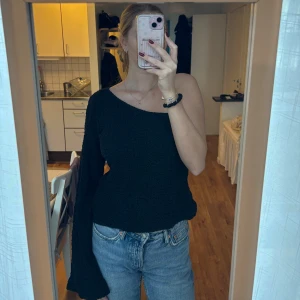 Svart oneshoulder topp från NA-KD - Svart oneshoulder topp från NA-KD. Tyget är med textur som syns på sista bilden. Storlek 38. 