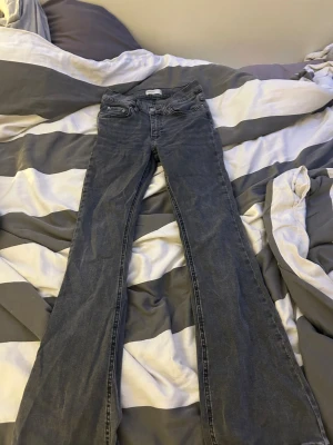 Grå bootcut jeans från Perfect Jeans - Snygga grå jeans från Perfect Jeans i bootcut-modell. Jeansen har klassisk femficksdesign, normalhög midja och raka ben som blir vidare nedtill. Materialet är mjukt denim i bomullsmix och färgen är en mörkgrå tvätt. Perfekta för dig som gillar en retroinspirerad look.