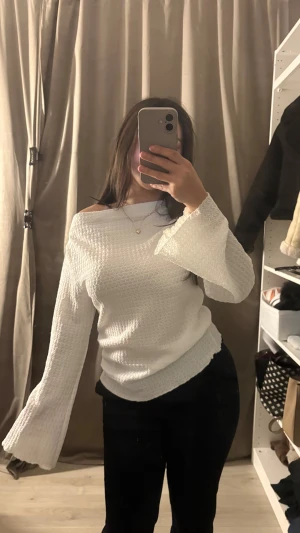 Vit halvt offshoulder topp från 157 - Säljer en vit offshoulder topp från 157 i storlek M. Toppen har ett snyggt strukturerat mönster och vida, långa ärmar som ger en cool vibe. Materialet känns mjukt och har en lätt stretch. Perfekt för dig som gillar att sticka ut med detaljer och stil.