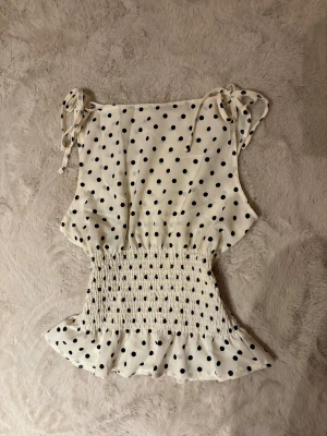 Prickig topp - Supersöt vit prickig topp med spänning runt midjan💕 storlek S