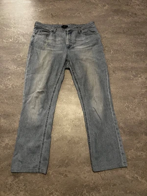 Blå jeans från Gant W34 L34 - Snygga blå jeans från Gant med klassisk femficksdesign och broderade bakfickor. Jeansen har en rak passform och är tillverkade i slitstarkt denimtyg. Perfekta för dig som gillar en tidlös och avslappnad stil.