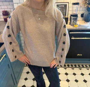 Beige stickad tröja med knappar - Supersnygg och cool tröja från Gina tricot som inte längre säljs, perfekt nu till vintern. Tröjan är iprincip aldrig använd och är i nyskick. Storlek S men har en oversized passform. Jag är 166 ish 🥰🥰🥰🫰🫰✌️