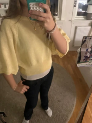 Gul croppad stickad tröja från Zara - Snygg ljusgul croppad stickad tröja från Zara med breda korta ärmar och rund hals. Perfekt för dig som gillar en chill och trendig look. Mjuk och skön kvalitet, passar till jeans eller kjol. Fräsch färg som lyser upp din outfit.