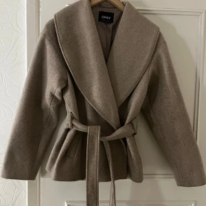 Beige kort kappa  - Snygg beige kappa från ONLY i storlek XS. Perfekt till hösten.