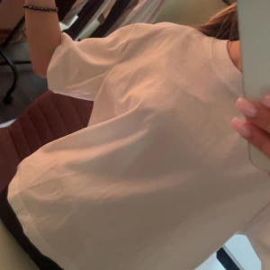 Vit oversized t-shirt i bomull - Enkel och stilren vit t-shirt med oversized passform. T-shirten har rund halsringning och korta ärmar, perfekt för en avslappnad look. Tillverkad i mjuk bomull som känns skön mot huden.