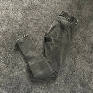 Replay Jeans - Snygga grå Replay jeans med slim passform och klassisk femficksdesign. Jeansen har raka ben och diskreta sömmar. Materialet är mjukt och stretchigt för extra komfort. Passar dig som gillar en stilren och enkel look.