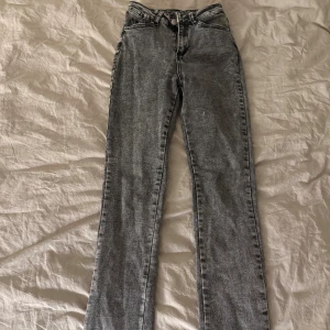 Gråa jeans  - Jeans som är lite lite utsvängda nertill med en slits.