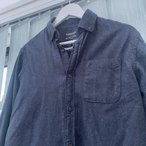 Mörkblå skjorta Jack & Jones - Mörkblå flanellskjorta från Jack & Jones Essentials, tillverkad i 100% bomull. Skjortan har klassisk krage, knappstängning framtill och en bröstficka | Passar för 175-180 | Hör av dig vid fler funderingar 👍