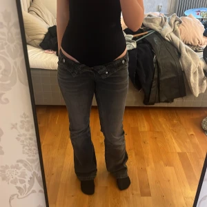 Grå bootcut jeans från Gina Tricot - Säljer ett par gråa bootcut jeans från Gina Tricot i storlek 164. Jeansen har mid midja, klassisk femficksdesign och är tillverkade i ett mjukt denimtyg. Snygg tvättad look och perfekt passform för dig som gillar en lite retro vibe.