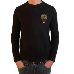 Svart stickad tröja från Morris - Svart stickad tröja från Morris med broderad logga. Perfekt för dig som gillar klassisk och stilren look.